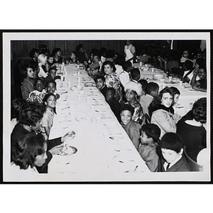Women and boys sit at tables during a Mothers' Club banquet