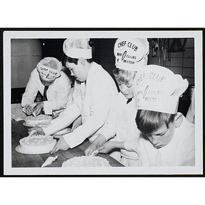 Members of the Tom Pappas Chefs' Club decorate cakes in a Brandeis University kitchen