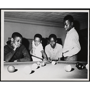 Four boys playing a game of pool at the Bunker Hill clubhouse