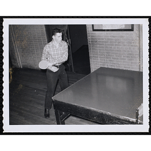 A teenage boy plays table tennis