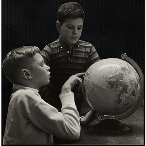 Two boys looking at a globe