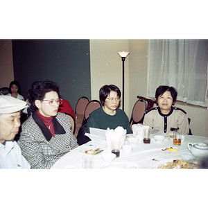 Women and a man sit at a restaurant table with food during a Chinese New Year celebration hosted by the Chinese Progressive Association