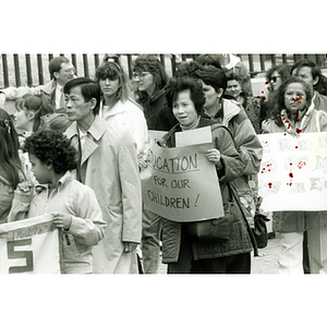 Demonstrators stand outside the Massachusetts State House holding signs, protesting for bilingual education in schools