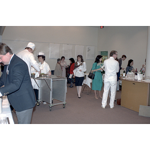 People chat and talk while chefs work at a food tasting event