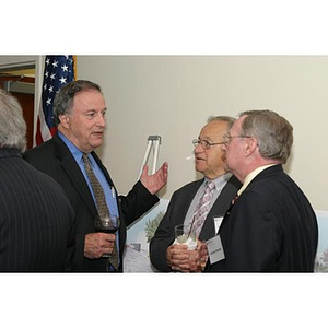 Three unidentified men converse at the Veterans Memorial dinner