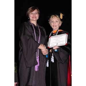 Dean Carole Kenner shakes hands with Pamela D. Gorgone at the School of Nursing convocation