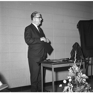 President Knowles stands at the unveiling of the portrait of Edward Hurtig during the dedication of Hurtig Hall