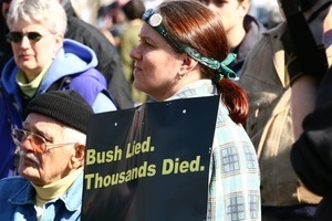 Woman protester holding a sign reading 'Bush lied. Thousands died': rally and march against the Iraq War