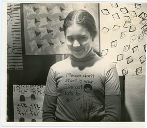 Rachel Saviano: half-length portrait of a young girl wearing a shirt reading 'Please don't start a war. I've got lots to do!'