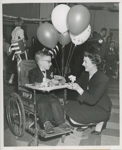 Little boy selling flowers from wheelchair