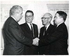 Boston Public Schools Superintendent William Ohrenberger with three unidentified men in front of sketch of City Hall