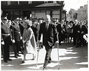 Mary Collins and Mayor John F. Collins walking through crowd past men in uniform