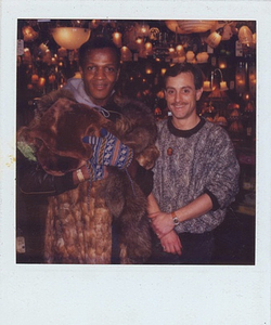 A Photograph of Marsha P. Johnson Wearing a Fur Coat and Winter Gloves, Posing with Another Person at Uplift Lighting