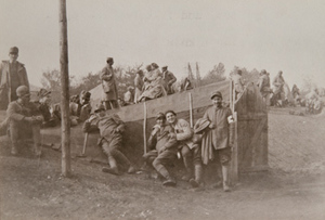 View of soldiers sitting in front of a dugout shelter