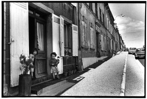 French children in front of house
