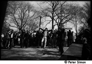 Resistance on the Boston Common: protesters raising arms and flashing peace signs near cross erected by anti-Communist counter-protesters from Polish Freedom Fighters Inc.
