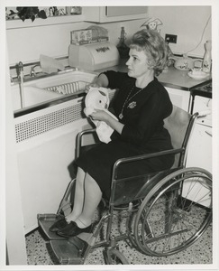 Mrs. Frances Marsala seated in her wheelchair washing dishes