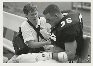 Athletic Trainer working on football player