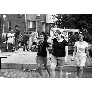 Three teenage girls walking through the plaza in Villa Victoria.