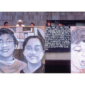 Portraits and passages of text decorate the balcony of a building overlooking the Plaza Betances.
