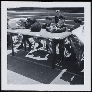 Several boys sitting at a table with their pets during a Boys' Club Pet Show