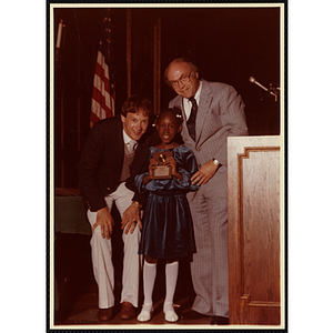 Regina Harris receives an award from Robert Cleary, Overseer of the Boys' Clubs of Boston, at right, and an unidentified man