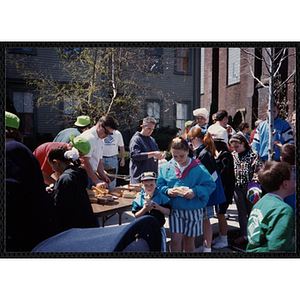 Several staff members making hot dogs for the children at the Boys and Girls Clubs of Boston 100th Anniversary Celebration Street Fair