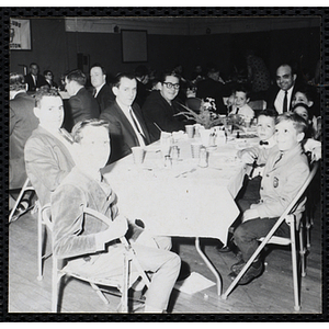 Men and boys pose for a shot at a table during a Dad's Club banquet