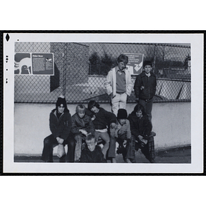 A group of boys poses in front a polar bear exhibit at a zoo