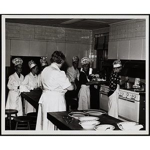 Members of the Tom Pappas Chefs' Club work in a kitchen under the supervision of Chefs' Club Committee member Mary Sciacca