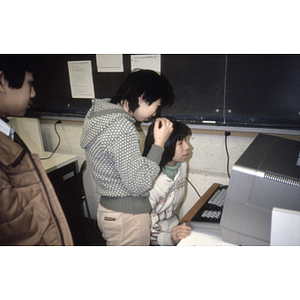 Three teenagers gather around a computer at a Chinese Progressive Association class