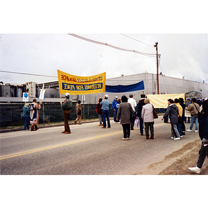 Striking workers and demonstrators stand in the road outside International Paper Company with signs and banners