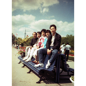 Chinese Progressive Association members sit together on a bench