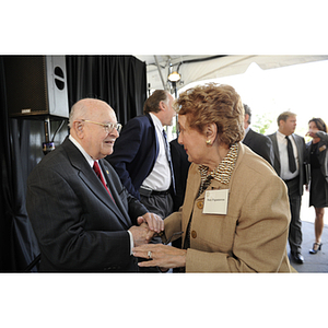 Dr. George J. Kostas shakes hands with Mary Papastavros at the groundbreaking ceremony for the George J. Kostas Research Institute for Homeland Security, located on the Burlington campus of Northeastern University