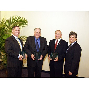 Three College of Business Administration alumni displaying their Distinguished Service Awards with Ira R. Weiss, Dean of the College of Business Administration