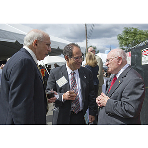 Three men stand talking during the reception for the George J. Kostas Research Institute for Homeland Security groundbreaking