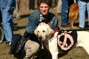 Protester with a dog wearing a vest decorated with a peace sign: rally and march against the Iraq War