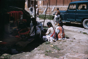Girls surround seller of yarn