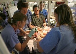 Nurse practitioner Martha Mance, left, inserts a breathing tube in baby Nicholas Chin, Cranston, who had respiratory problems at birth