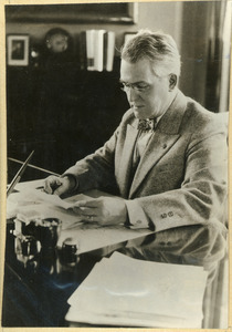 Hugh P. Baker reading at his office desk