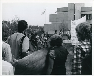 Board of Trustees fee increase demonstration: protestors listening to speaker, Whitmore Administration Building in background
