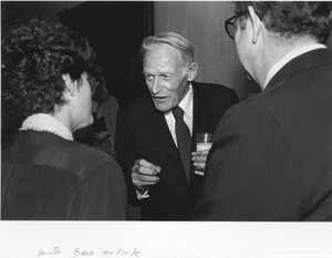 Frederick Troy indoors talking with two unidentified people