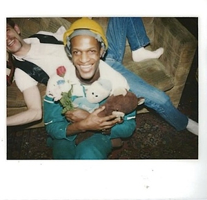 A Photograph of Marsha P. Johnson Wearing a Construciton Hat and Holding Stuffed Animals