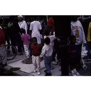 Children and adults on a crowded sidewalk