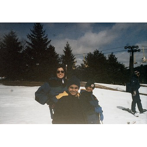 Woman and two boys near the ski lift on a ski trip organized by Inquilinos Boricuas en Acción's Youth Programs, Human Services Department.
