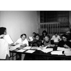 Women studying paperwork in a class.