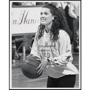 Former Olympic figure skater Nancy Kerrigan holding a basketball and looking up at a fund-raising event held by the Boys and Girls Clubs of Boston and Boston Celtics