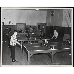 Boys play table tennis in a hall