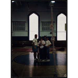 A group of children and a supervisor with a climbing rope in the foreground