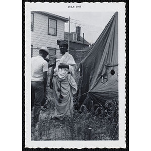 A teenage boy poses in front of a tent in a yard during Tom Sawyer Day